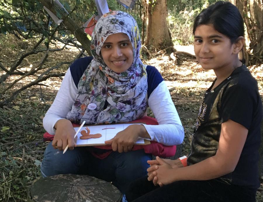 Two girls, one in headscarf, in the woods